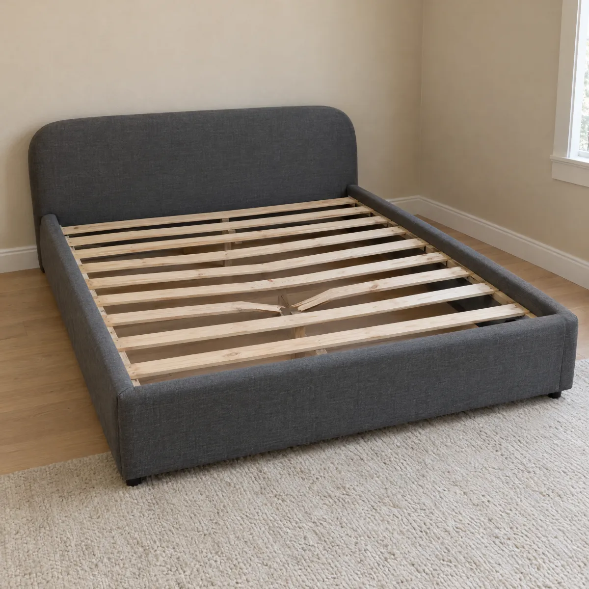 A basic store-bought bed frame with thin slats, one snapped in the middle.